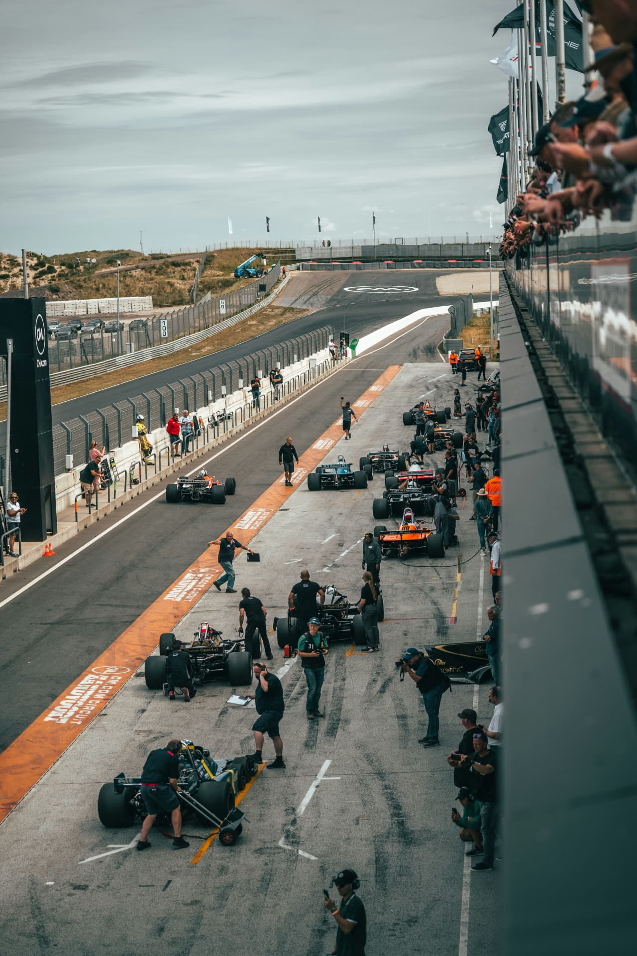 Pit lane busy with race cars and teams